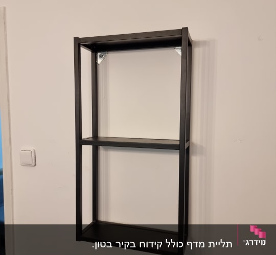 מדף מתכת שחור מותקן על קיר לבן